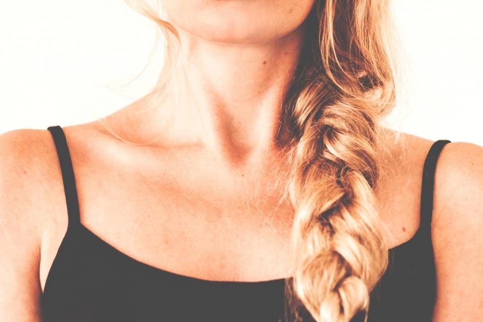 A loose blonde braid over one shoulder